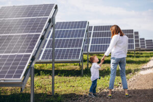 mother with her little son next to solar panels