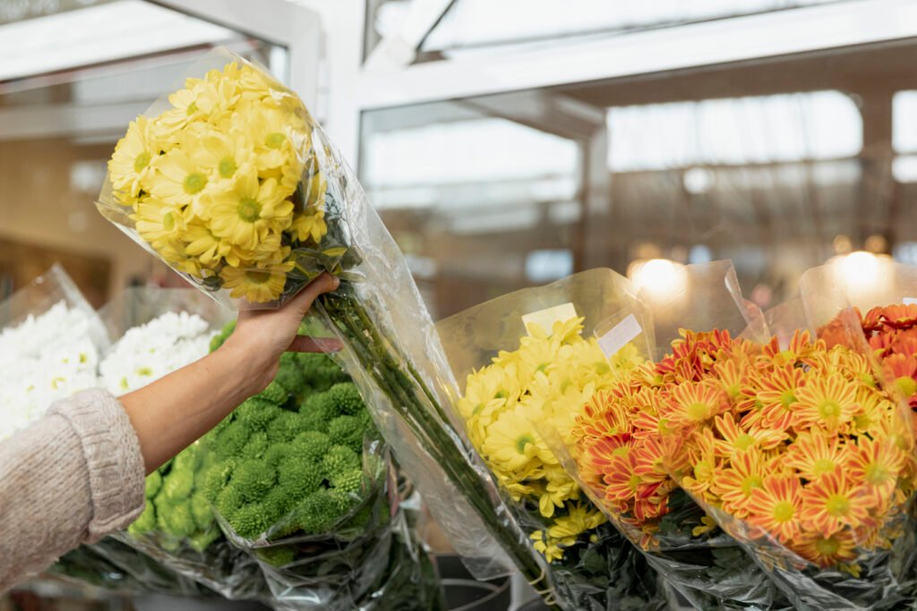 Flowers in plastic wrap being chosen at the supermarket
